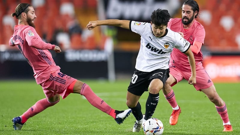 Lee Kang-in of Valencia is tackled by Madrid's Sergio Ramos.
