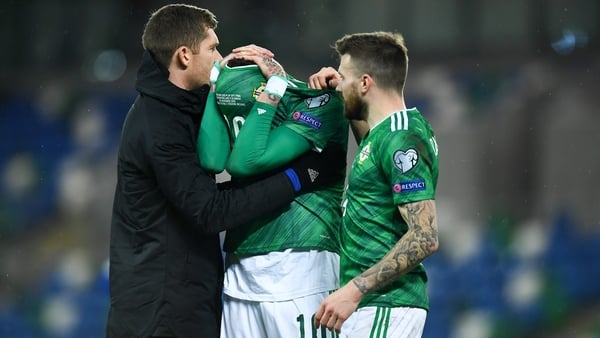 McGovern (L) and Stuart Dallas console Kyle Lafferty after the Slovakia defeat.