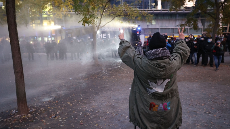 A protester reacts as police use water cannon to disperse a demonstration against coronavirus restrictions yesterday in Frankfurt