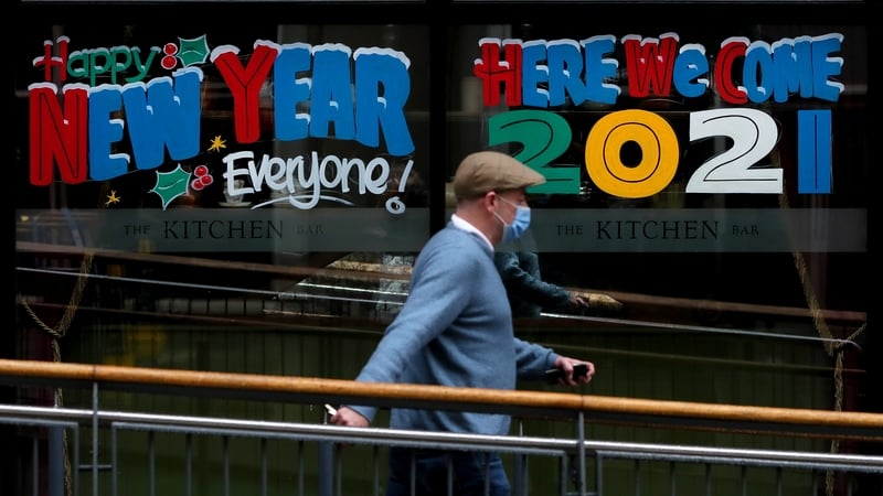 A man walks past a pub window sign in Belfast city centre
