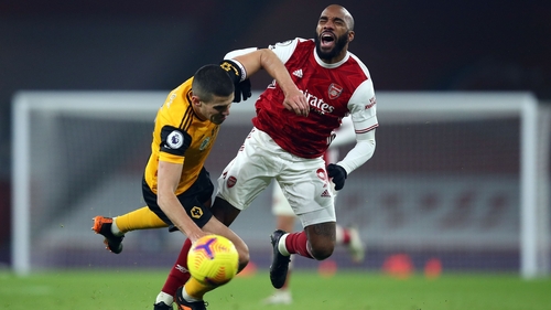 Conor Coady of Wolves and striker Alexandre Lacazette clash at the Emirates.