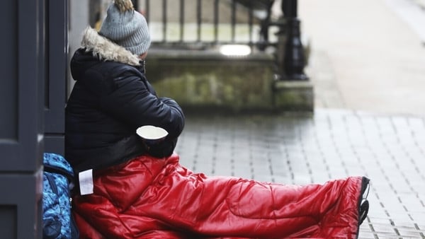 Homeless person sitting on pavement
