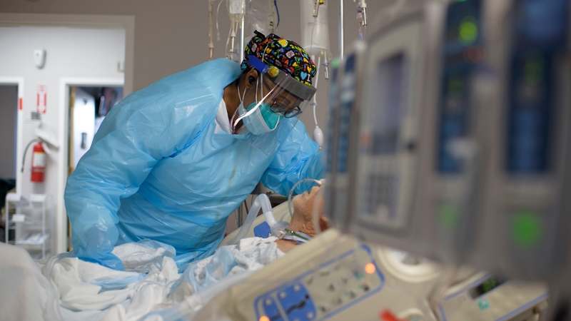 A healthcare worker comforts a Covid-19 patient at United Memorial Medical Center in Houston, Texas