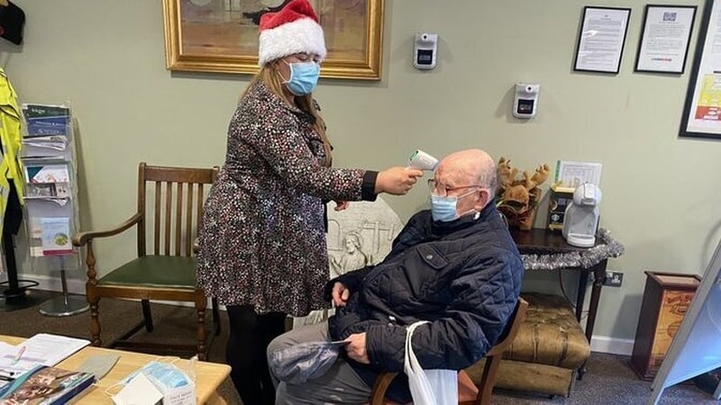 Roy Brown gets a temperature check before visiting his wife Ann at St Joseph's Nursing Home Shankill in Dublin