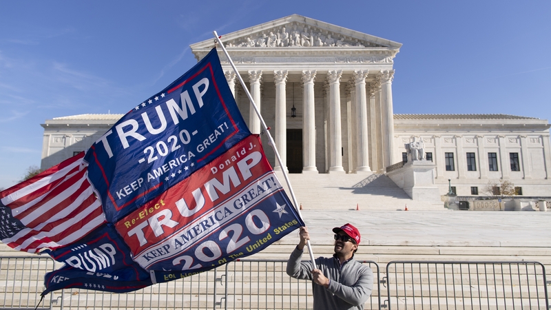 A supporter of US President Donald Trump holds a flag outside the Supreme Court in Washington, DC