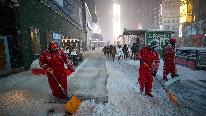 Workers clean snow at the Times Square during snowfall in New York City