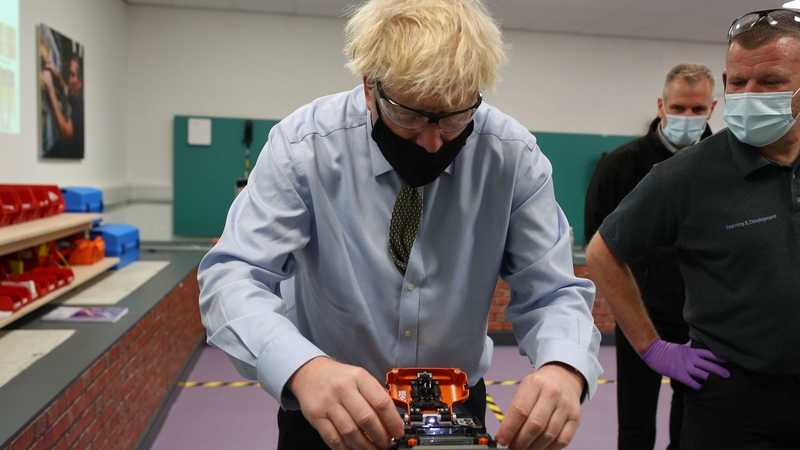 Boris Johnson tries his hand at cable splicing during a visit to a training centre in Greater Manchester