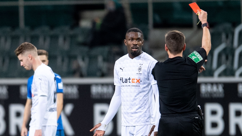 Referee Frank Willenborg shows Monchengladbach's French forward Marcus Thuram the red card