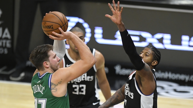 Luka Doncic of the Dallas Mavericks shoots over Paul George