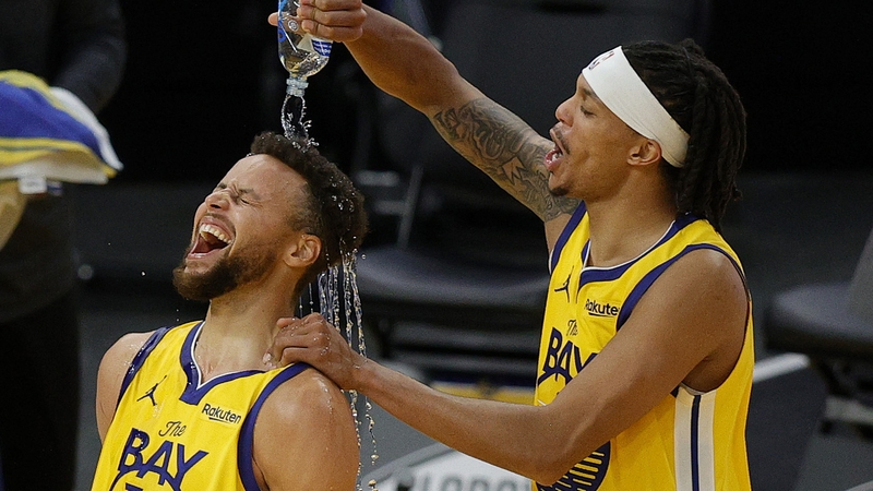 Steph Curry (L) is showered in water by Damion Lee