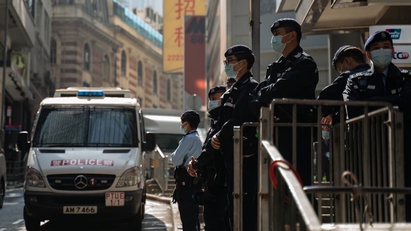 Police officers stand guard near the office of human rights lawyer John Clancey