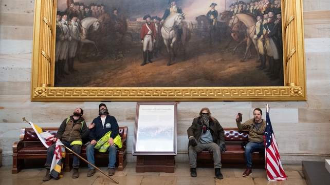 Trump supporters take a seat beneath a painting showing the final surrender of British troops under Lord Cornwallis after the Battle of Yorktown in 1781
