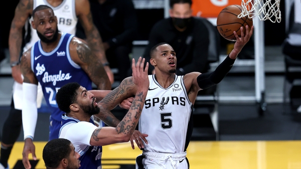 Dejounte Murray of the San Antonio Spurs lays up a shot past the defense of Anthony Davis