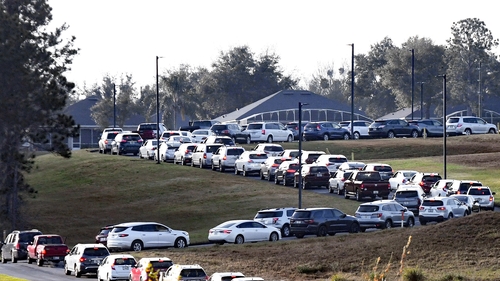 Hundreds of cars line up as people wait to receive a dose of the Pfizer Covid-19 vaccine at a drive-thru vaccination event in Florida