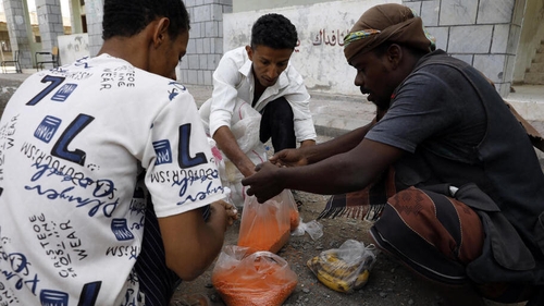 Yemenis share grain of food rations provided by an aid group, amid a dire humanitarian crisis, in the western port city of Hodeidah