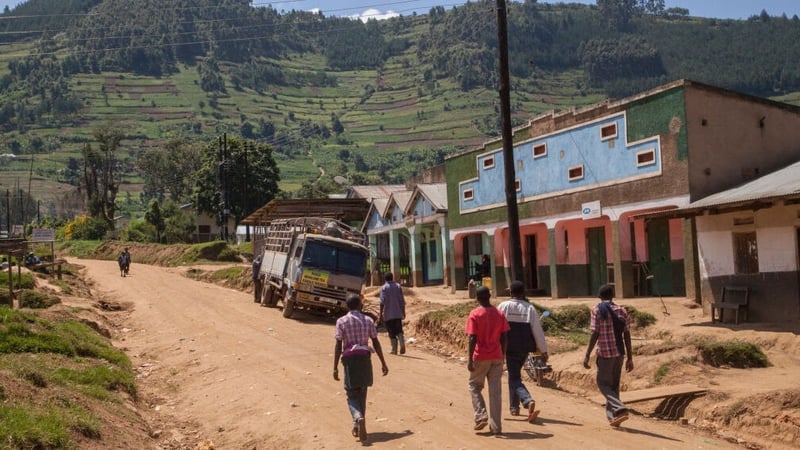 People walk in a town near Bwindi Impenetrable National Park, in Uganda