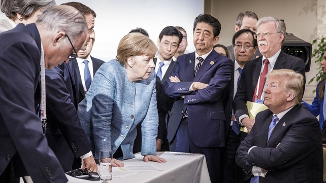 German Chancellor Angela Merkel deliberates with Donald Trump on the sidelines of the 2018 G7 summit in Canada. Other leaders seen in the picture are French president Emmanuel Macron and then British prime minister Theresa May