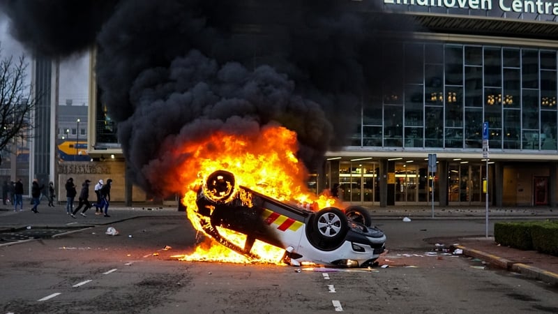 A car is overturned and set ablaze during a protest near Eindhoven Central Station yesterday