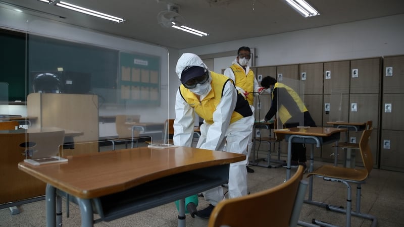 Workers sanitise a classroom in Seoul