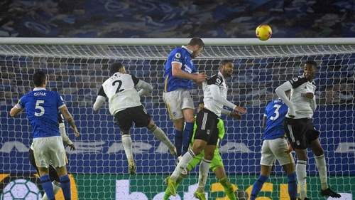 Brighton defender Adam Webster (C) wins a header