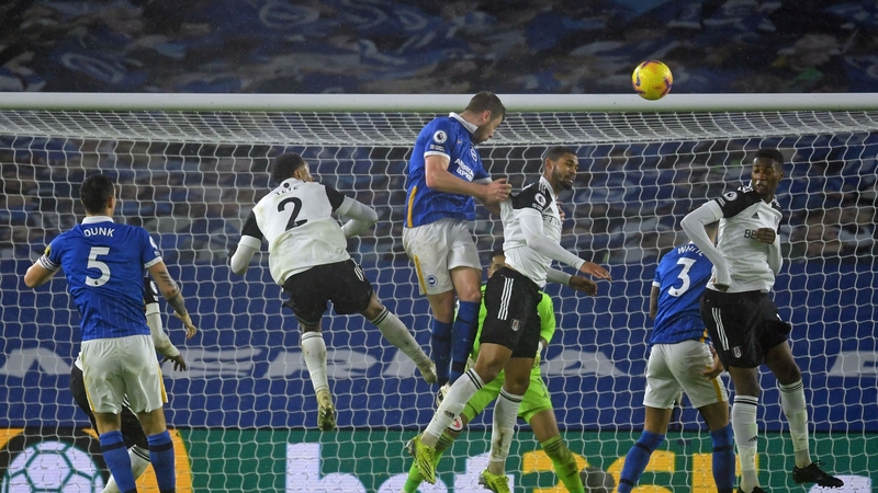 Brighton defender Adam Webster (C) wins a header