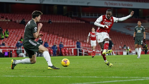 Manchester United defender Harry Maguire(L) blocks a shot from Arsenal's midfielder Nicolas Pepe