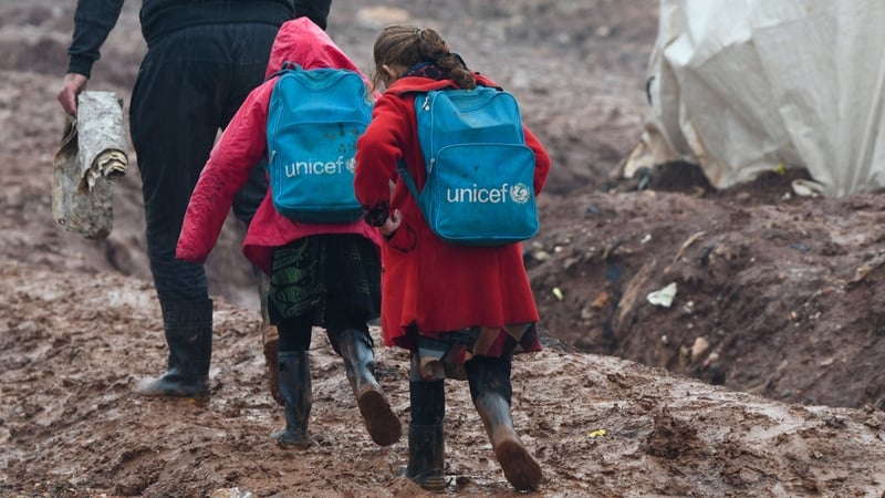 Children are led to school in the Atme camp close to the border with Turkey in Syria's northwestern Idlib province