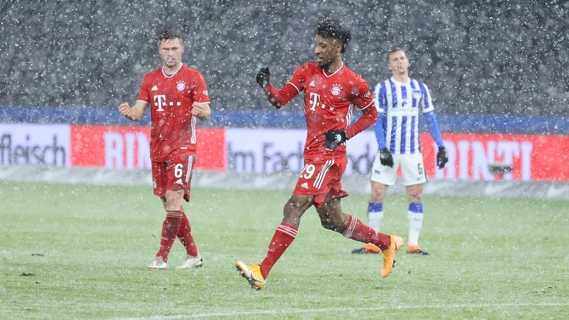 Bayern Munich goalscorer Kingsley Coman celebrates as the snow falls at the Olympiastadion in Berlin