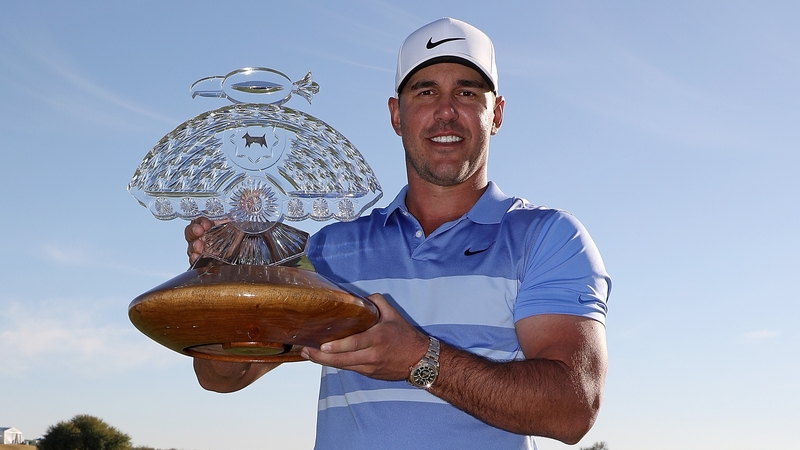 Brooks Koepka poses with the trophy