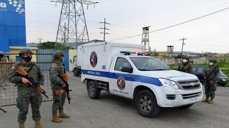 Members of the military guard the prison in Guayaquil as a prisoner's body is removed