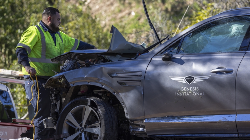 A sign for the Genesis Invitational golf tournament is seen on the door of the car Tiger Woods was driving