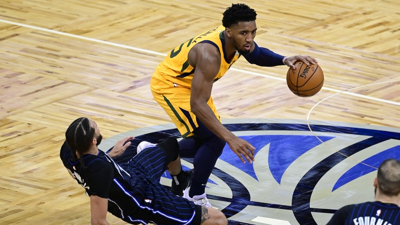 Donovan Mitchell dribbles the ball as he is fouled by Orlando Magic's Michael Carter-William