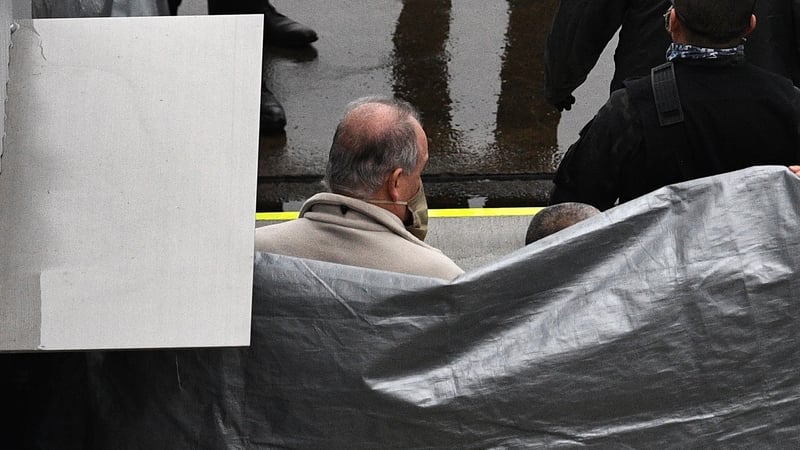 A man understood to be former US special forces member Michael Taylor is escorted away on his arrival in Tokyo