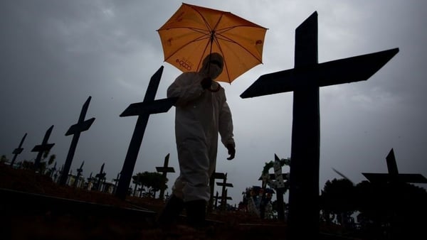 A worker walks past the graves of Covid-19 victims at the Nossa Senhora Aparecida Cemetery in the Brazilian city of Manaus