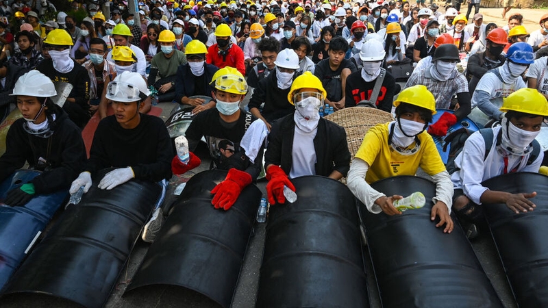 Protesters hold homemade shields as they prepare to face off against security forces in the city of Yangon