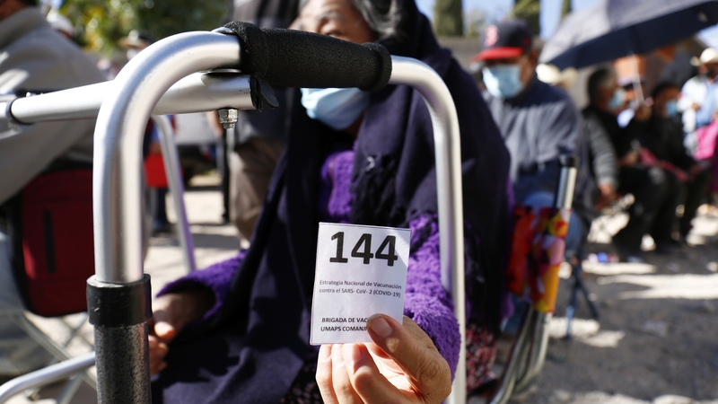 A woman shows her number in the queue for a Covid vaccine in Leon, Mexico