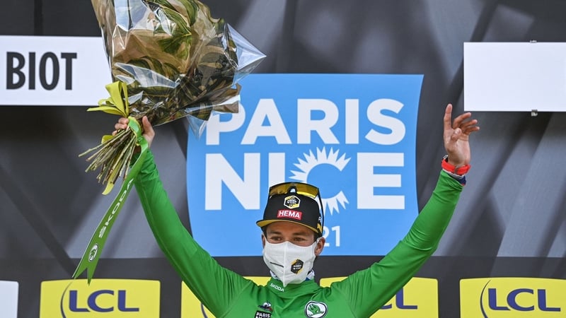 Primoz Roglic celebrates after taking hold of green jersey for best sprinter on the podium at the end of the sixth stage