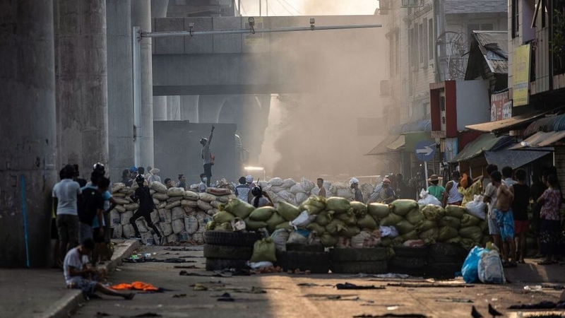 Protesters stand near makeshift barricades during anti-coup demonstrations in Yangon