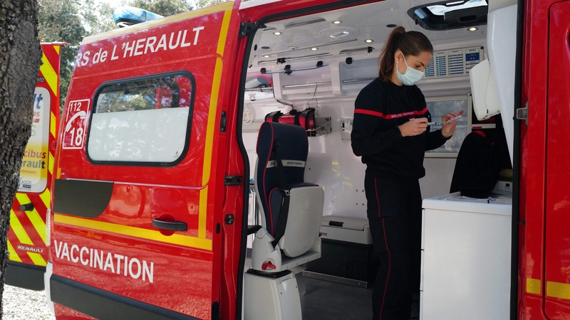A firefighter prepares a Pfizer-BioNTech vaccine for a patient at home in Les Matelles, southern France