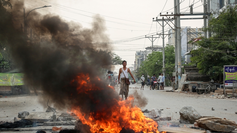 Debris burns during a protest in Mandalay