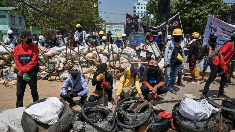 Protesters gather by a barricade in Yangon