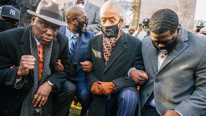 Attorney Ben Crump (L), Rev Al Sharpton (C) and the family of George Floyd kneel for eight minutes 46 seconds outside the court