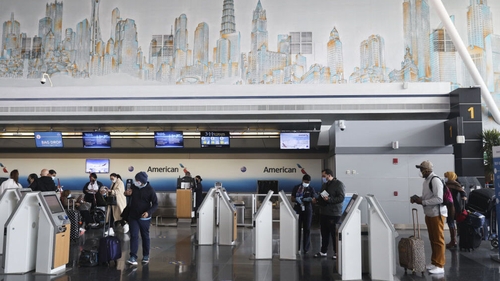 Travellers wearing masks checking-in for flights at JFK International Airport in New York (file pic)