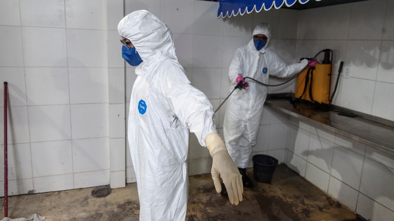 Workers of the Emergency Medical Care Service disinfect their suits after helping people with Covid-19 in Salvador, capital of the Brazilian state of Bahia