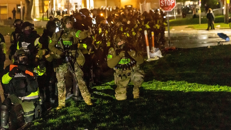 Minnesota state troopers prepare to fire tear gas at protesters