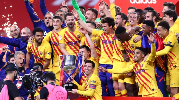 Barcelona captain Lionel Messi poses with the trophy in front of his team-mates
