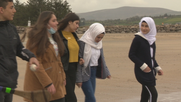 Eman and Amany walk on the beach with friends