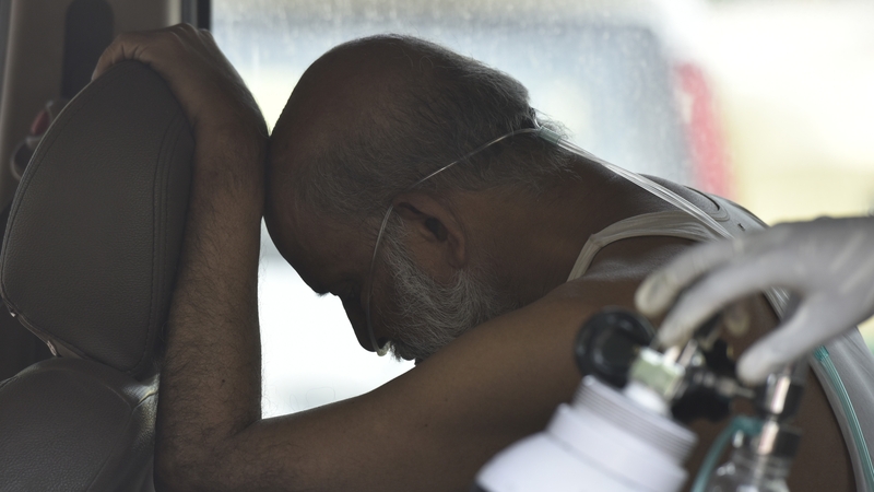 A man waits for admission to hospital in New Delhi