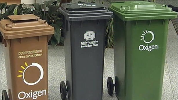 A brown, a black and a green wheelie bin
