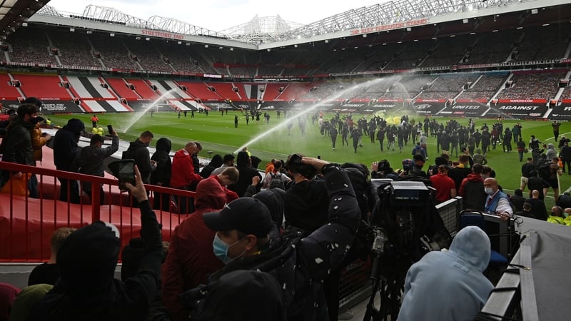 Supporters stream on to the Old Trafford pitch